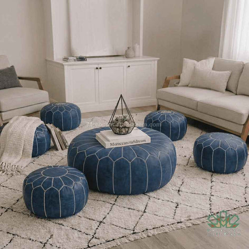 Living room with blue poufs and a white sofa on a patterned rug.