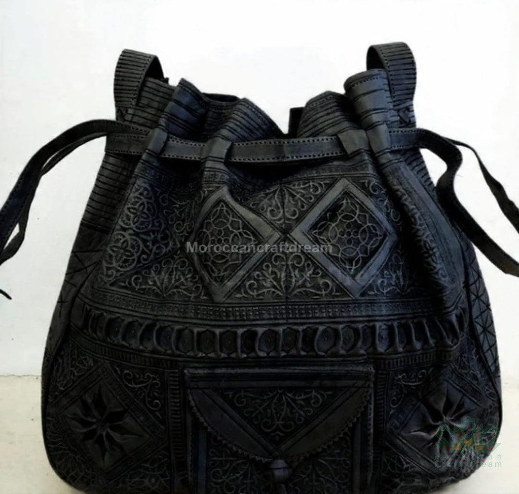 Black embroidered handbag with intricate patterns on a white background
