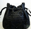 Black embroidered handbag with intricate patterns on a white background