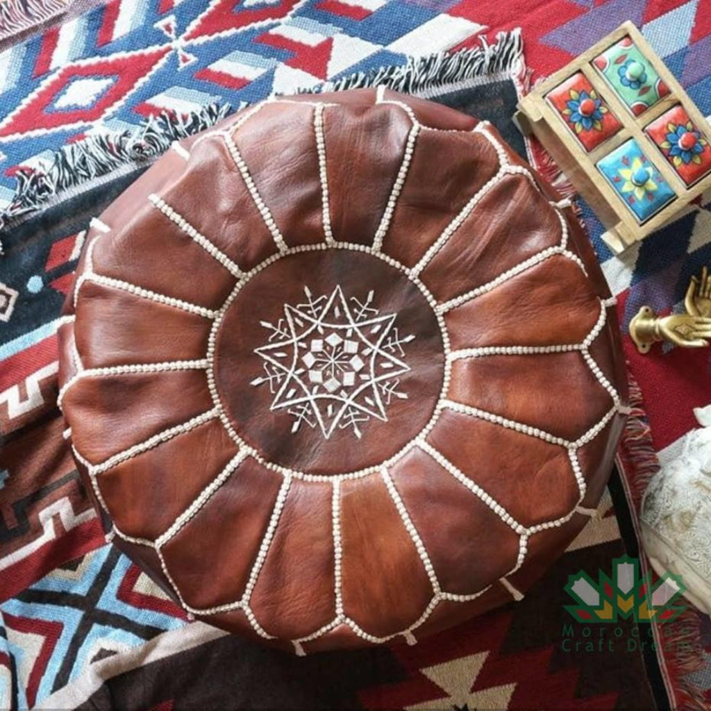 Round Moroccan leather poufs used as a coffee table, handcrafted with durable materials and traditional stitching in natural tones.